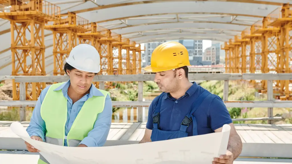 Équipe d'architectes qui relit les plans d'un projet sur le chantier, la matière d'un portfolio architecte