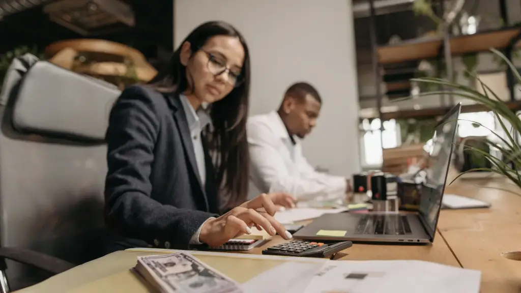 Collaborateurs d'un cabinet d'expertise comptable qui travaillent sur ordinateur et calculatrice
