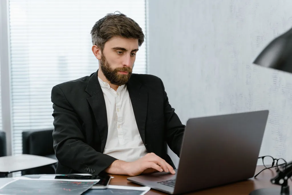 Dirigeant PME qui analyse les performances SEO de son site sur un ordinateur portable