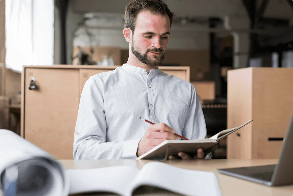 jeune-homme-tenue-ecriture-journal-bureau 1-min.png