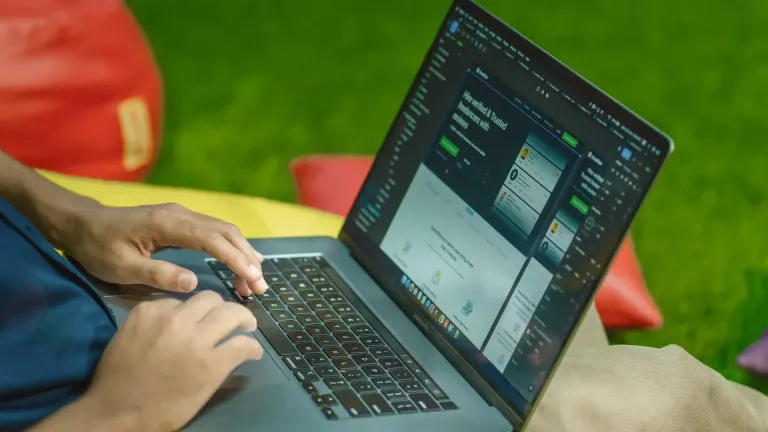 Homme qui consulte un site internet sur son ordinateur portable en plein soleil, où le contraste compte