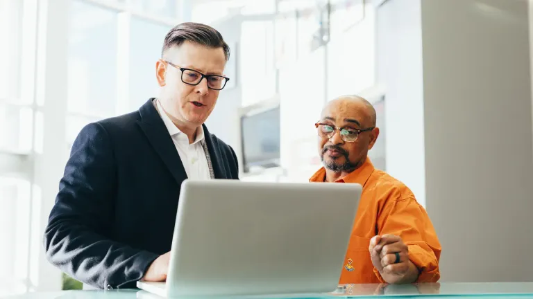 Dirigeant de PME et commercial qui choisissent un CRM sur ordinateur portable