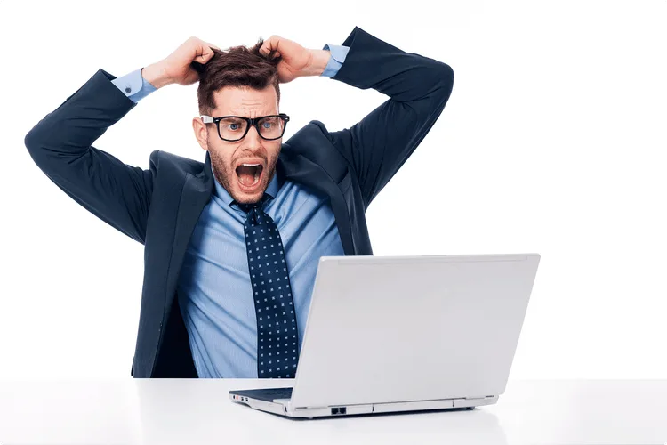 Un homme surprise en regardant son ordinateur