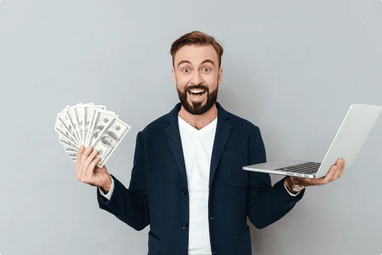Homme tenant de l'argent et un ordinateur dans ses mains