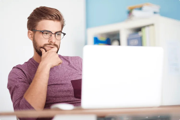 homme se posant des questions devant son ordinateur