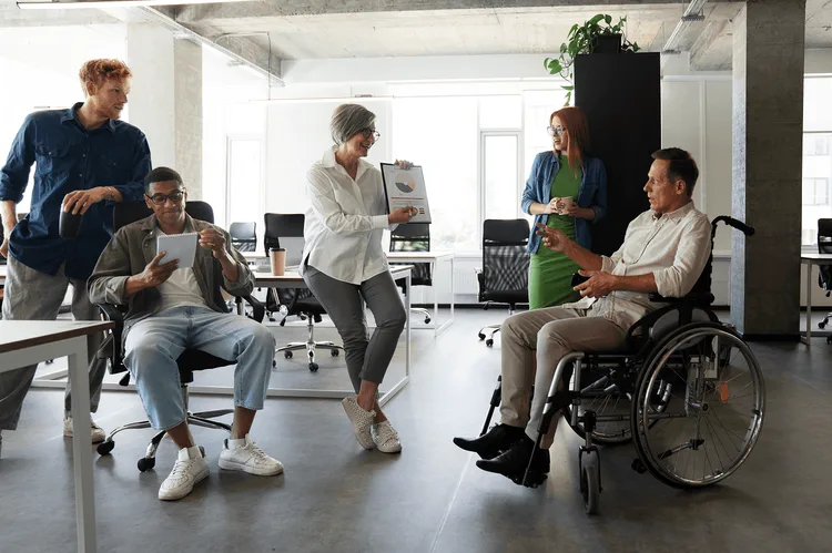Collègue avec une personne en fauteuil roulant dans des locaux