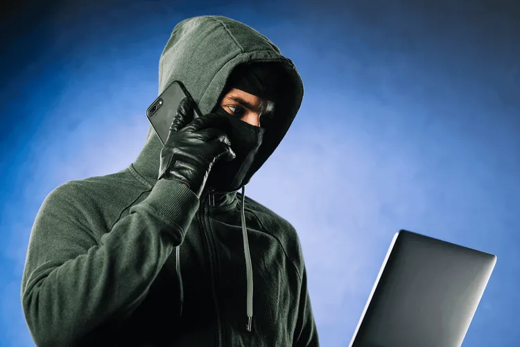 Hacker qui est au téléphone sur son ordinateur