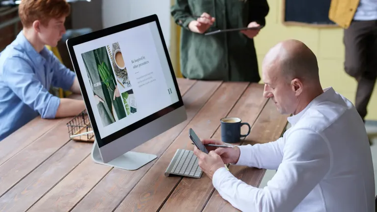 Dirigeant de PME qui consulte son site web sur smartphone en situation de mobilite