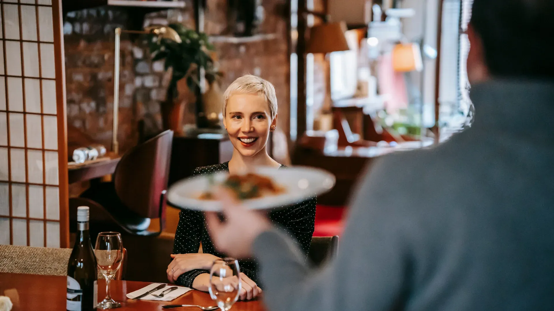 Serveur apporte les plats à des clients satisfaits au restaurant