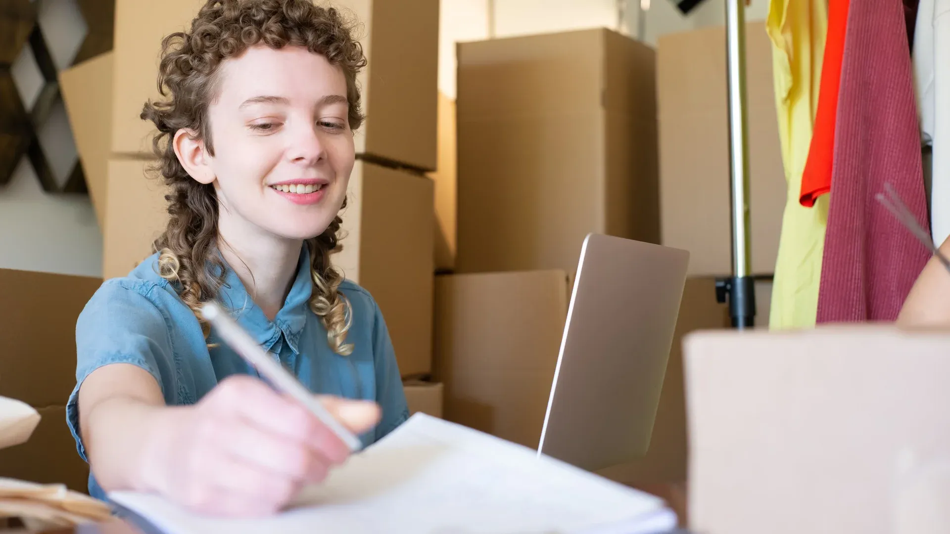 Dirigeante de PME qui prépare ses commandes et pèse le choix de sa plateforme e-commerce